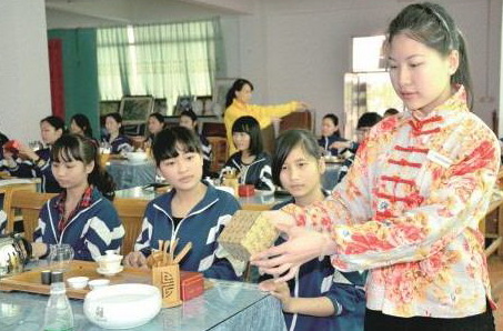 茶藝師正在給英德市職業(yè)技術(shù)學(xué)校茶藝興趣班學(xué)生演示茶藝的標準動作。